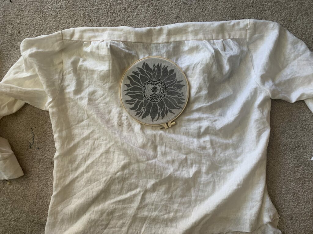 A sunflower embroidery pattern has been added to the back of a linen shirt